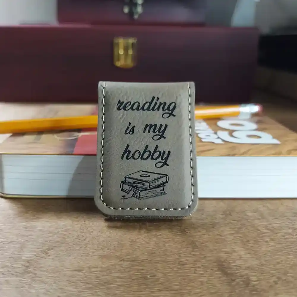 Magnetic bookmark with engraved design leaning on book