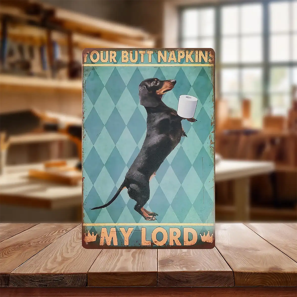 Vintage style metal sign with dachshund standing holding toilet paper. Sign reads "Your Butt Napkins my Lord".